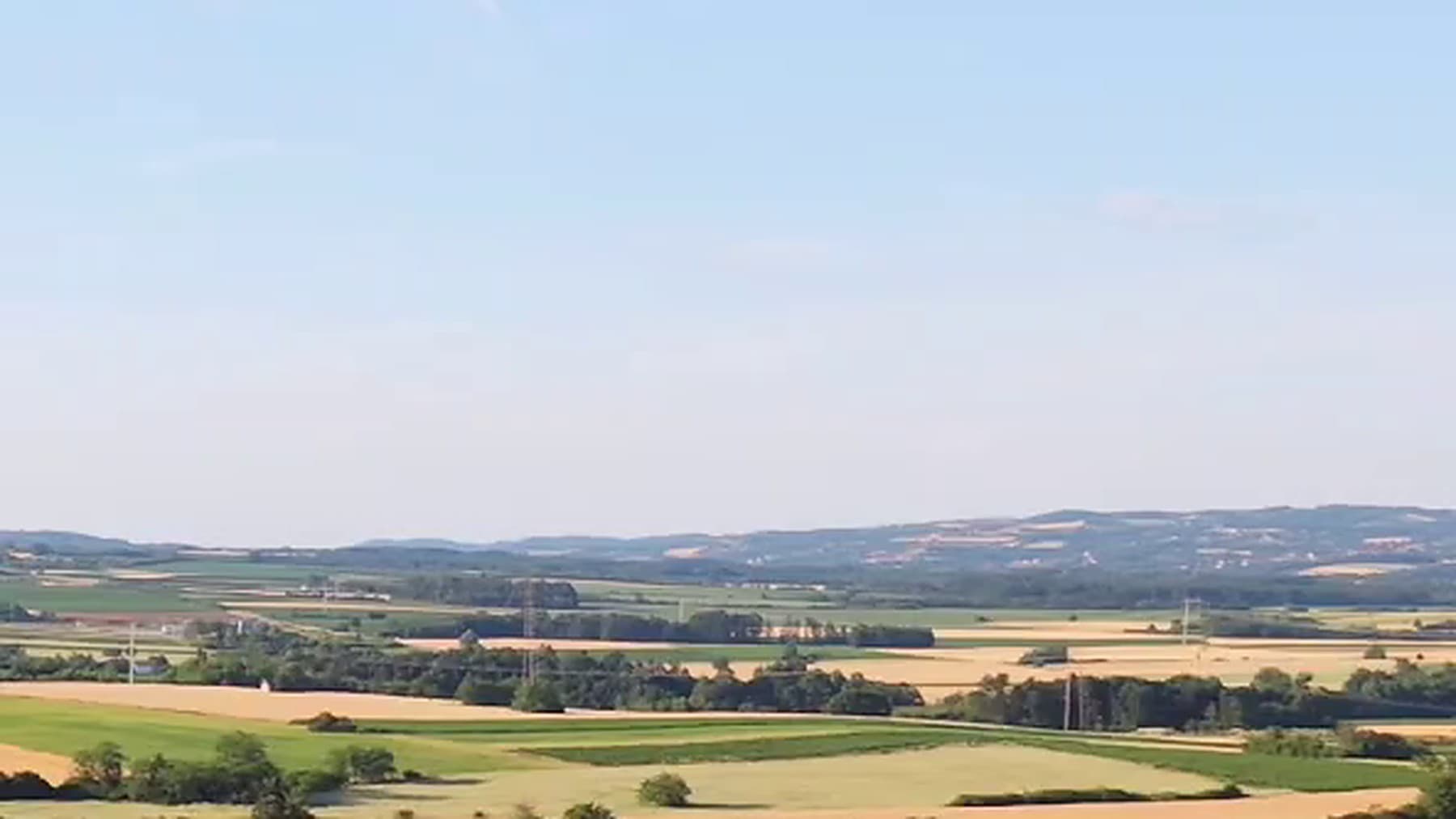 Panorama šumadijske doline sa njivama oko zasada.